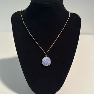 Gold necklace with purple stone.